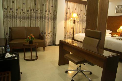 a hotel room with a desk and a bed at Zimbo Golden Hotel in Dar es Salaam