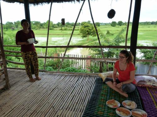 two women sitting on the porch of a safari tent at Battambang Dream Bungalows in Battambang