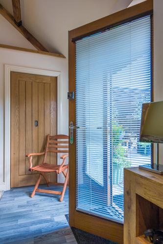 a room with a window with a chair and a table at Widbrook Barns in Bradford on Avon