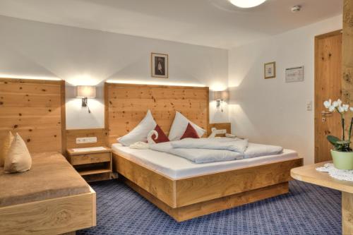 ein Schlafzimmer mit einem großen Bett in einem Zimmer in der Unterkunft Bergsporthotel Antonie in Gries im Sellrain