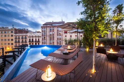 a rooftop deck with tables and chairs and a swimming pool at Ocean Drive Barcelona in Barcelona