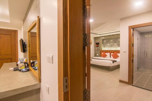 a hallway leading to a bedroom with a bed and a bathroom at Chhay Long Angkor Boutique Hotel Siem Reap in Siem Reap