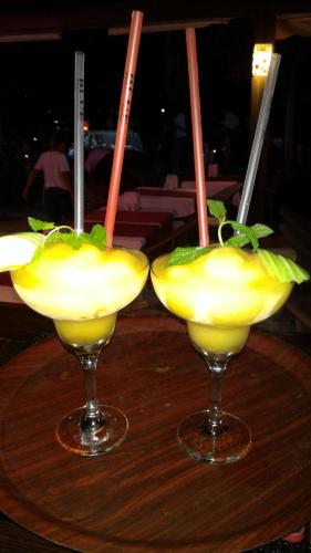 due cocktail seduti su un tavolo di legno con bevande di Dinc Pension a Bodrum City