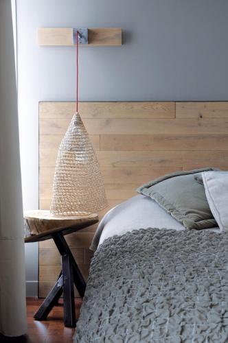 a bedroom with a bed and a pendant lamp at Hôtel De Paris in Sète