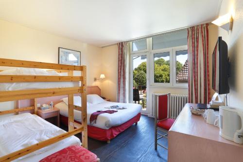a bedroom with two bunk beds and a window at The Originals City Hotel de l Ange Guebwiller in Guebwiller