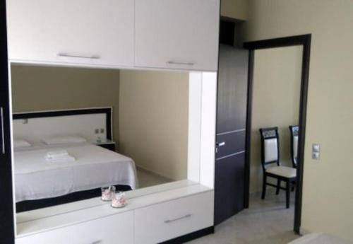 a bedroom with a bed with a mirror and a chair at Villa Xristos Kalogeris in Ksamil