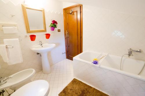 a white bathroom with a sink and a tub and a toilet at Frascati Country House in Grottaferrata