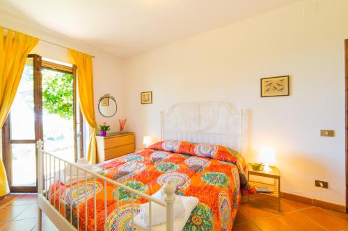 a bedroom with a bed with a colorful bedspread at Frascati Country House in Grottaferrata