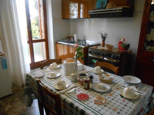una cocina con una mesa con platos y platos. en B&B Il Sentiero di Assisi, en Asís