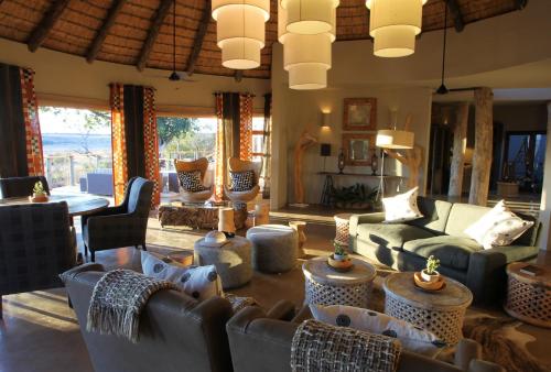 a living room with couches and chairs and a table at Nambiti Plains Lodge in Nambiti Private Game Reserve