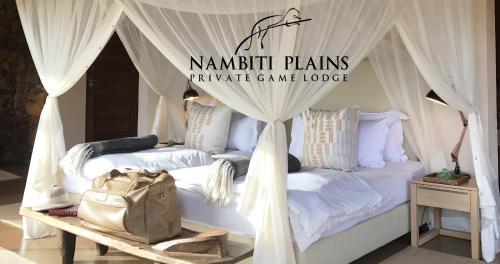 a bedroom with a bed with a canopy at Nambiti Plains Lodge in Nambiti Private Game Reserve