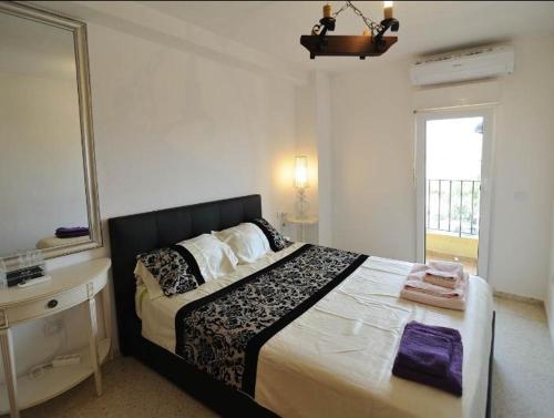 1 dormitorio con cama, lavabo y espejo en First line apartment, en Alboraya