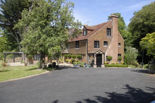 uma casa grande com uma entrada em frente em Cleavers Lyng 16th Century Country House em Herstmonceux