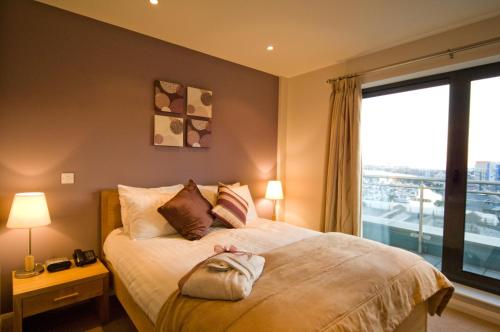 a bedroom with a bed with a large window at Liberty Wharf Apartments in Saint Helier Jersey