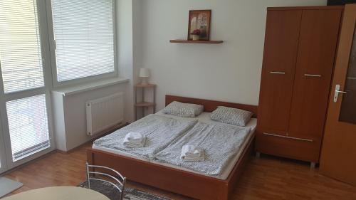 a bedroom with a bed with two towels on it at Golem Tatranská Štrba in Tatranska Strba