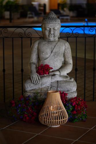 a stone statue with flowers and a vase at Paloma Blanca Boutique Hotel in Marbella