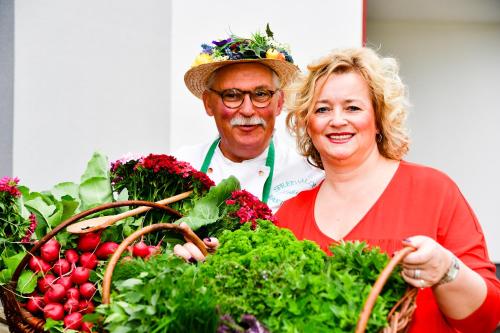 a man and a woman holding a basket of vegetables at Hotel Zum Stern Spreewald in Werben