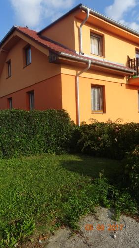 a yellow house with a hedge in front of it at Penzion Relax Martina in České Budějovice