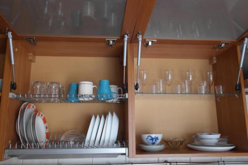 ノヴォシビルスクにあるSalvador Apartments Krasny prospectの食器、皿、グラスが入った戸棚