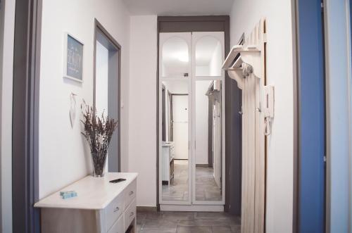 a hallway with a mirror and a dresser in a room at Balokány apartman in Pécs