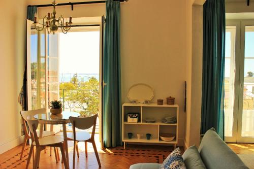 a living room with a table and a dining room at Alojamentos Vista Mar-Luisa Todi in Setúbal