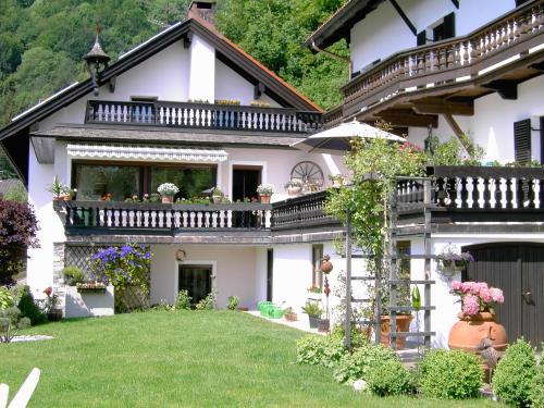 a white house with a balcony and a yard at Gästehaus Katharina in Kiefersfelden