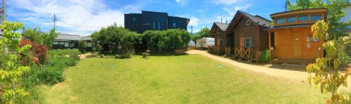 a large yard with a building in the background at Tomareru Himitsukichi L-Base in Matsumoto