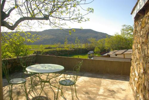 a table and chairs on a patio with a view of a mountain at gîte de la garde in Prévenchères