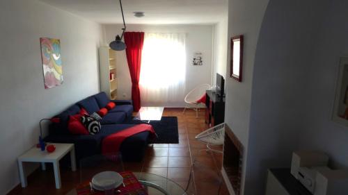 a living room with a blue couch and a window at Lagunilla Rural in Fuente de Piedra