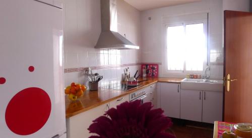a kitchen with white cabinets and a sink and a window at Lagunilla Rural in Fuente de Piedra