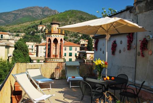 eine Terrasse mit einem Tisch, Stühlen und einem Sonnenschirm in der Unterkunft Parmigiana in Levanto