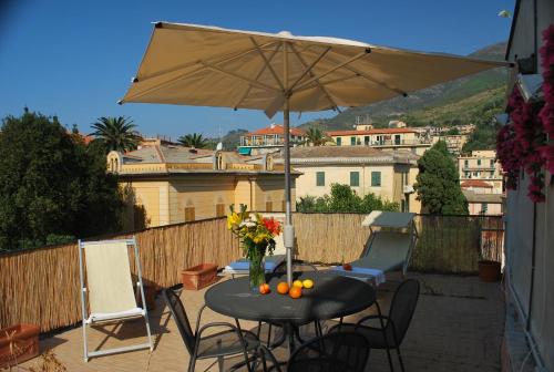 einen Tisch und Stühle mit Sonnenschirm auf einer Terrasse in der Unterkunft Parmigiana in Levanto