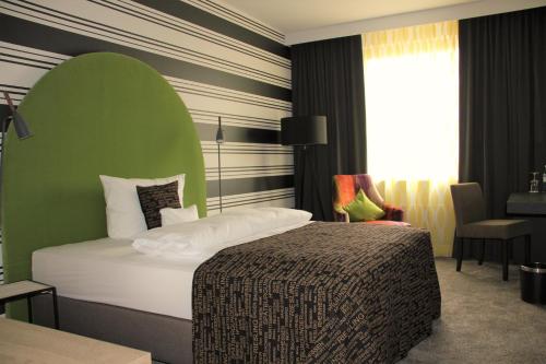 a bedroom with a bed with a green headboard at Nägler´s Fine Lounge Hotel in Oestrich-Winkel