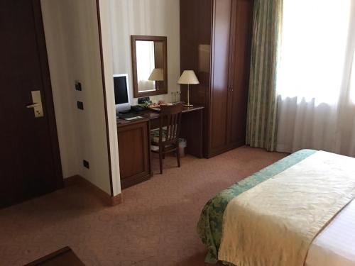 a hotel room with a bed and a desk with a computer at Hotel Otrada in Odesa