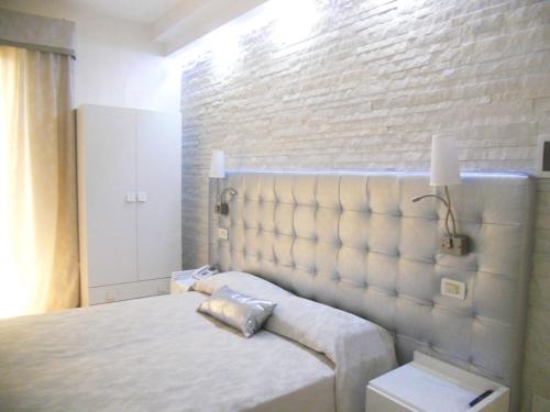 a bedroom with a bed and a brick wall at Hotel Azzurra in Lido degli Estensi
