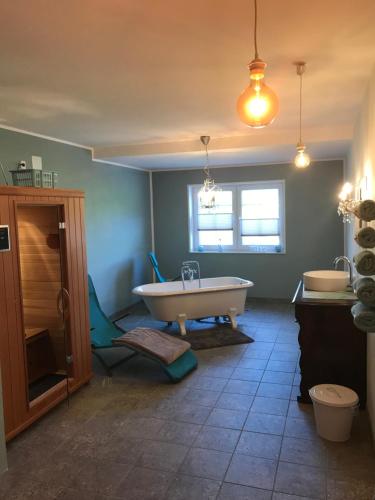 een badkamer met een bad en 2 wastafels bij Artgerecht Ferienhäuser in Bad Berleburg