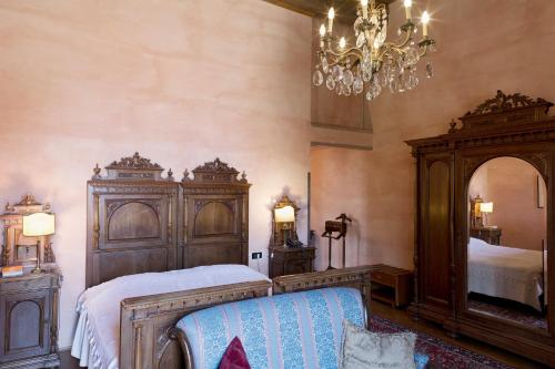 a bedroom with a bed and a chandelier at Hotel Locanda Dei Mai Intees in Azzate