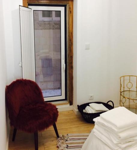 a living room with a chair and a window at Apartments Alfacinha Ajuda in Lisbon