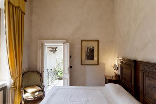 a bedroom with a bed and a door to a balcony at Hotel Locanda Dei Mai Intees in Azzate