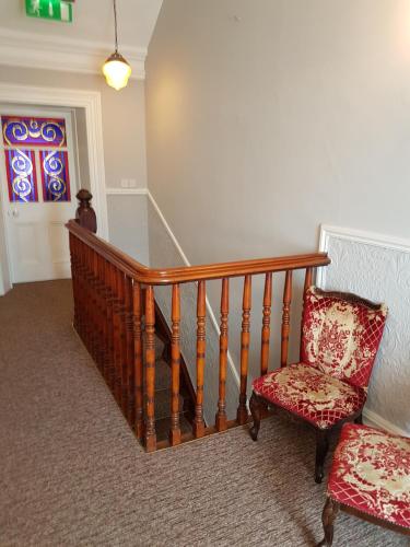 a stairway with a chair and a stair case at JBs Bar & Guest Accommodation in Kilkenny