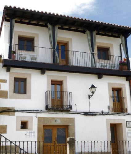 a white building with windows and balconies at Apartamentos Rurales Entre Fuentes in Cuacos de Yuste