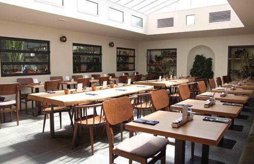 una sala da pranzo con tavoli e sedie in legno di c-hotels Diplomat a Firenze