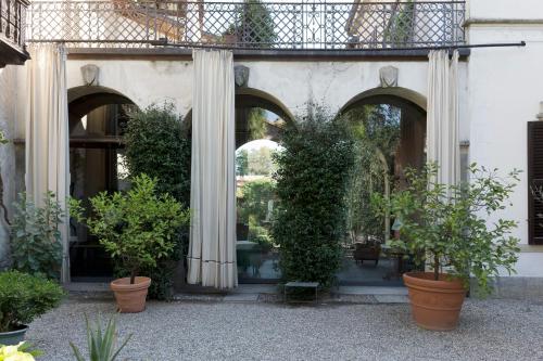 a building with columns and potted plants in a courtyard at Hotel Locanda Dei Mai Intees in Azzate
