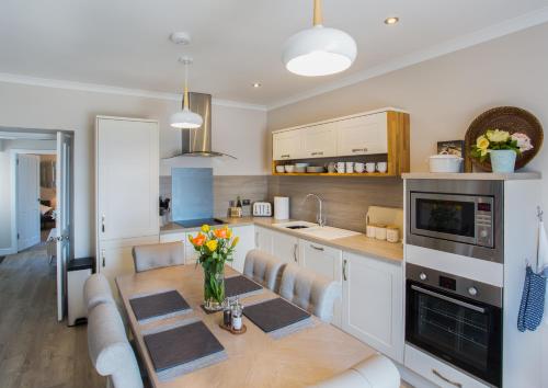 uma cozinha com uma mesa de madeira e uma sala de jantar em Shore View Cottage em Inverness