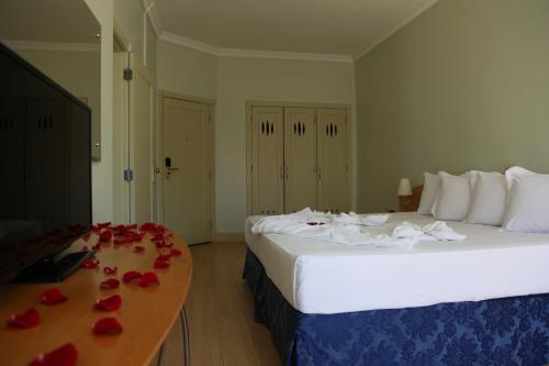 a hotel room with two beds and roses on a table at San Raphael Hotel in Sao Paulo