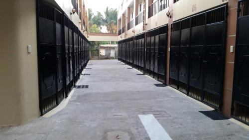an empty hallway with black horse stalls in a building at Hotel Georgina in Maitim