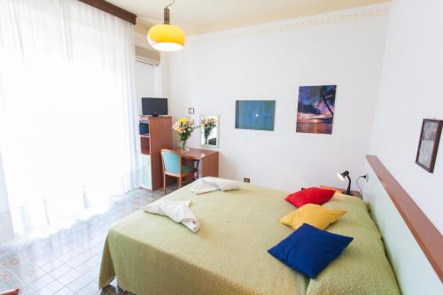 タビアーノにあるHotel Quisisanaのベッドルーム1室(大型ベッド1台、カラフルな枕付)