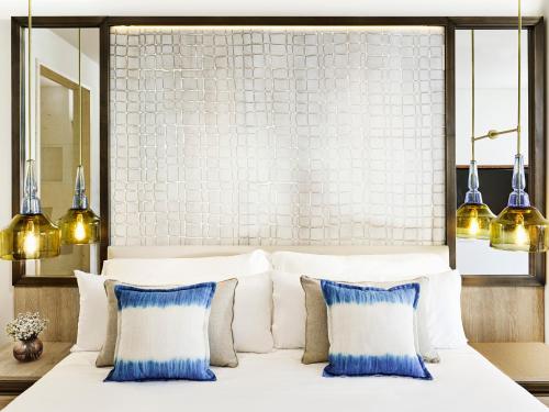 
a white bed with a white comforter and pillows at Nobu Hotel Ibiza Bay in Talamanca
