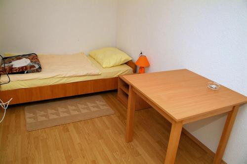 a small bedroom with a bed and a table at Prenociste Denis in Velika