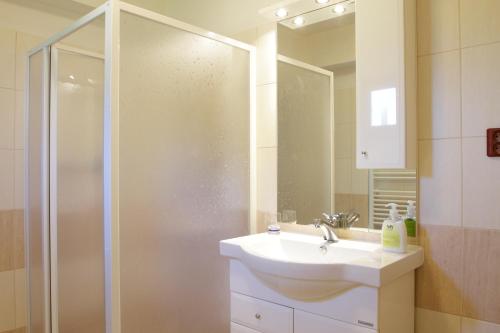 a bathroom with a sink and a shower with a mirror at Apartmán Jana in Štiavnické Bane